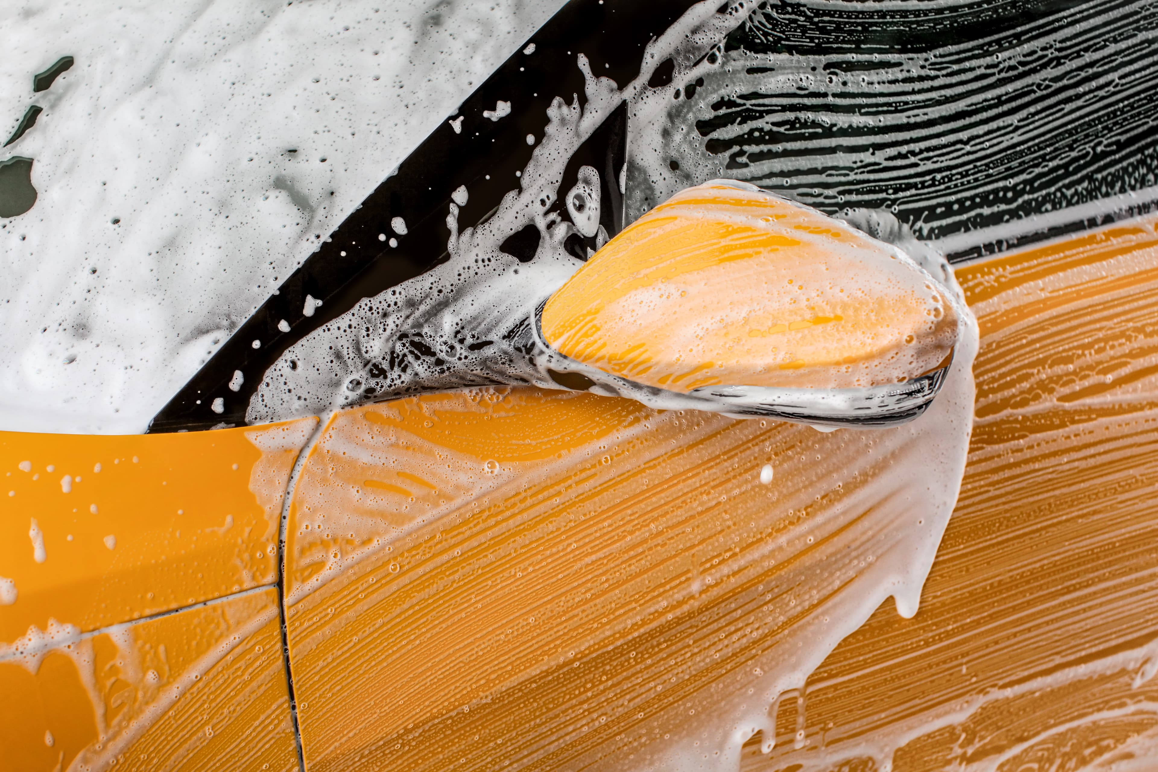 detail-strokes-left-by-brush-shampoo-foam-front-mirror-car-washed-carwash